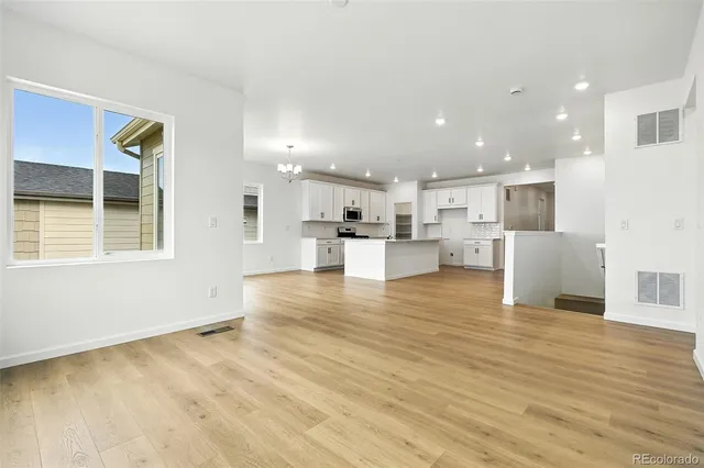 a kitchen with stainless steel appliances granite countertop a stove top oven a sink and white cabinets