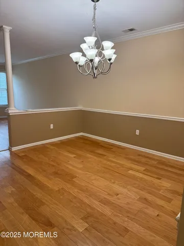 a view of a room with wooden floor and chandelier