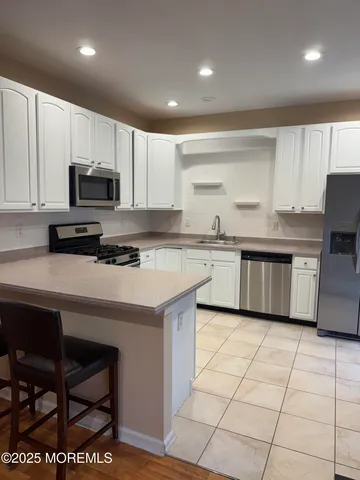a kitchen with stainless steel appliances a stove a sink a microwave a refrigerator and cabinets