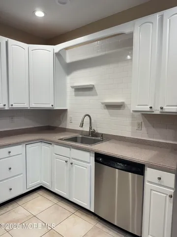 a kitchen with white cabinets appliances and a sink