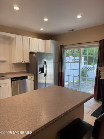 a kitchen with stainless steel appliances a refrigerator sink and cabinets
