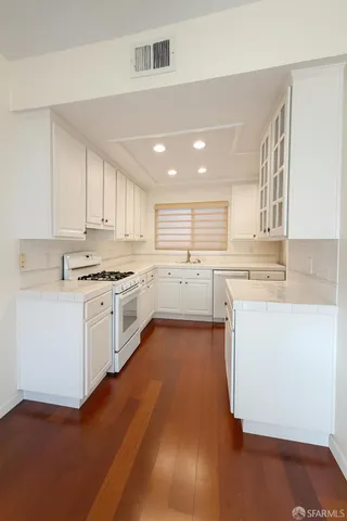 a kitchen with a sink window and stainless steel appliances