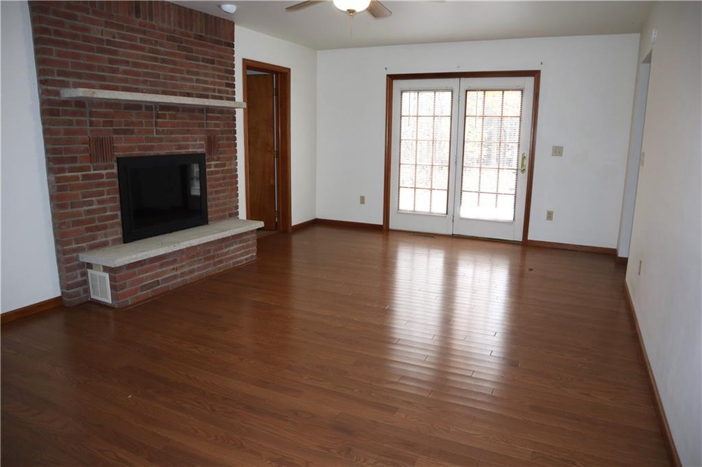1600 Ramsey Run Road Indiana, PA 15701 - Photo 14 of 50 an empty room with wooden floor fireplace and windows