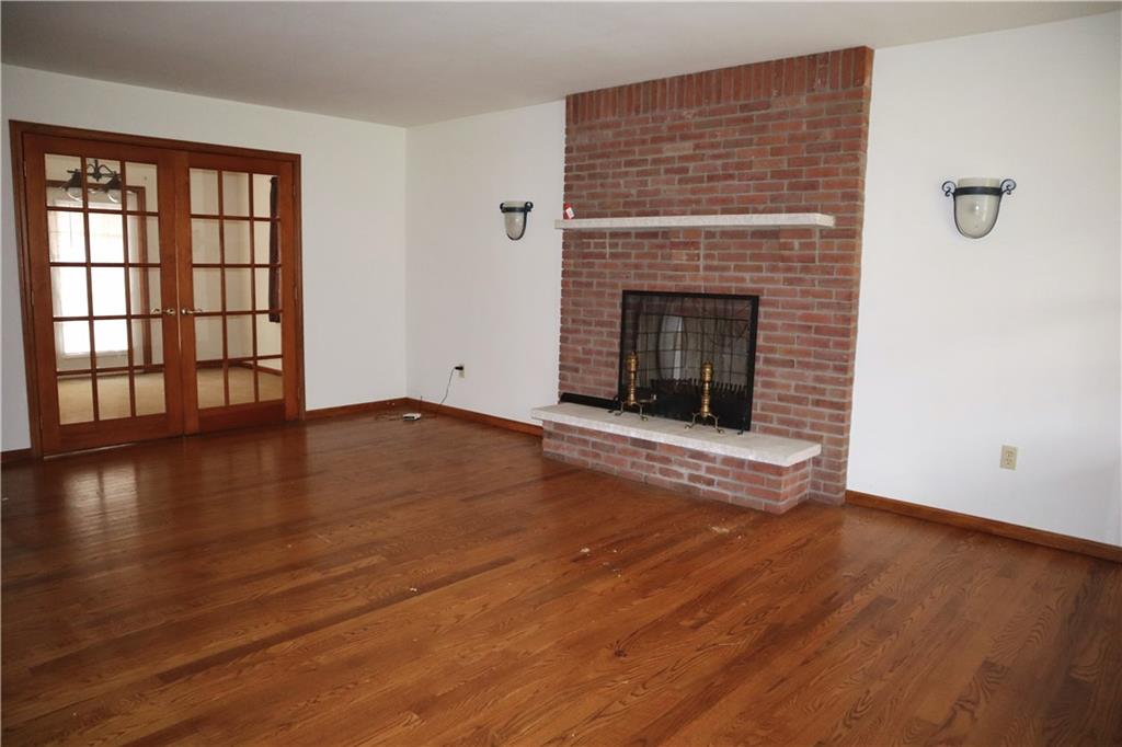 1600 Ramsey Run Road Indiana, PA 15701 - Photo 5 of 50 an empty room with wooden floor and fireplace