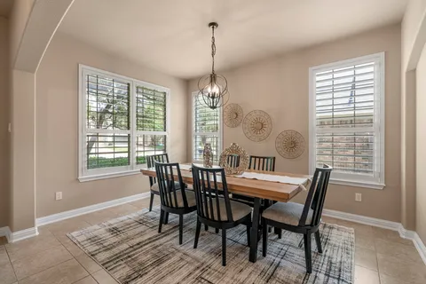a dining room with furniture a chandelier and wooden floor