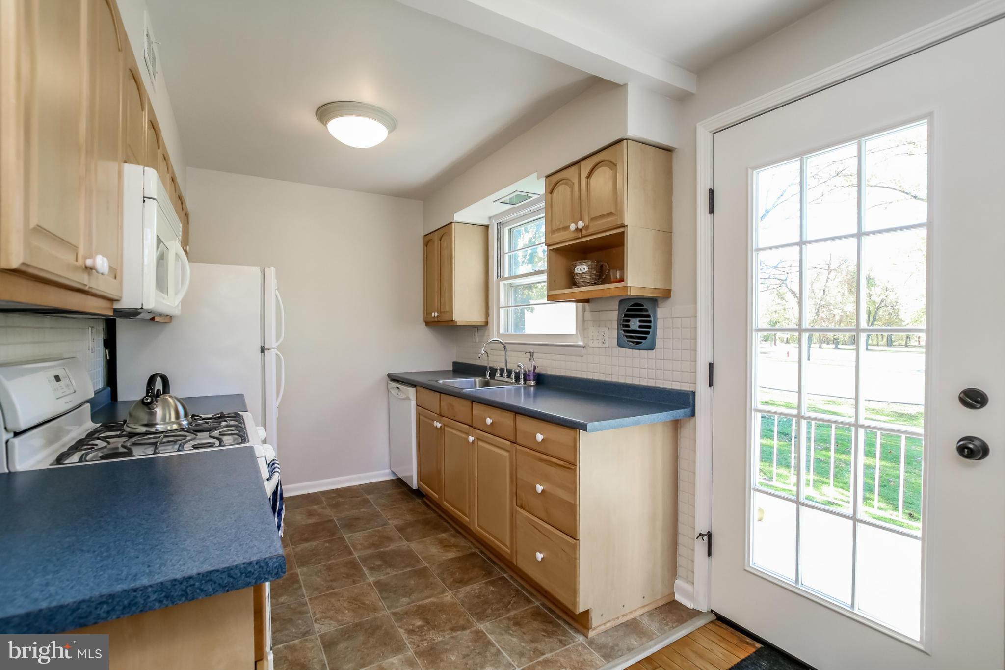 832 Templecliff Road Pikesville, MD 21208 - Photo 11 of 30 a kitchen with stainless steel appliances granite countertop a sink a stove and a refrigerator