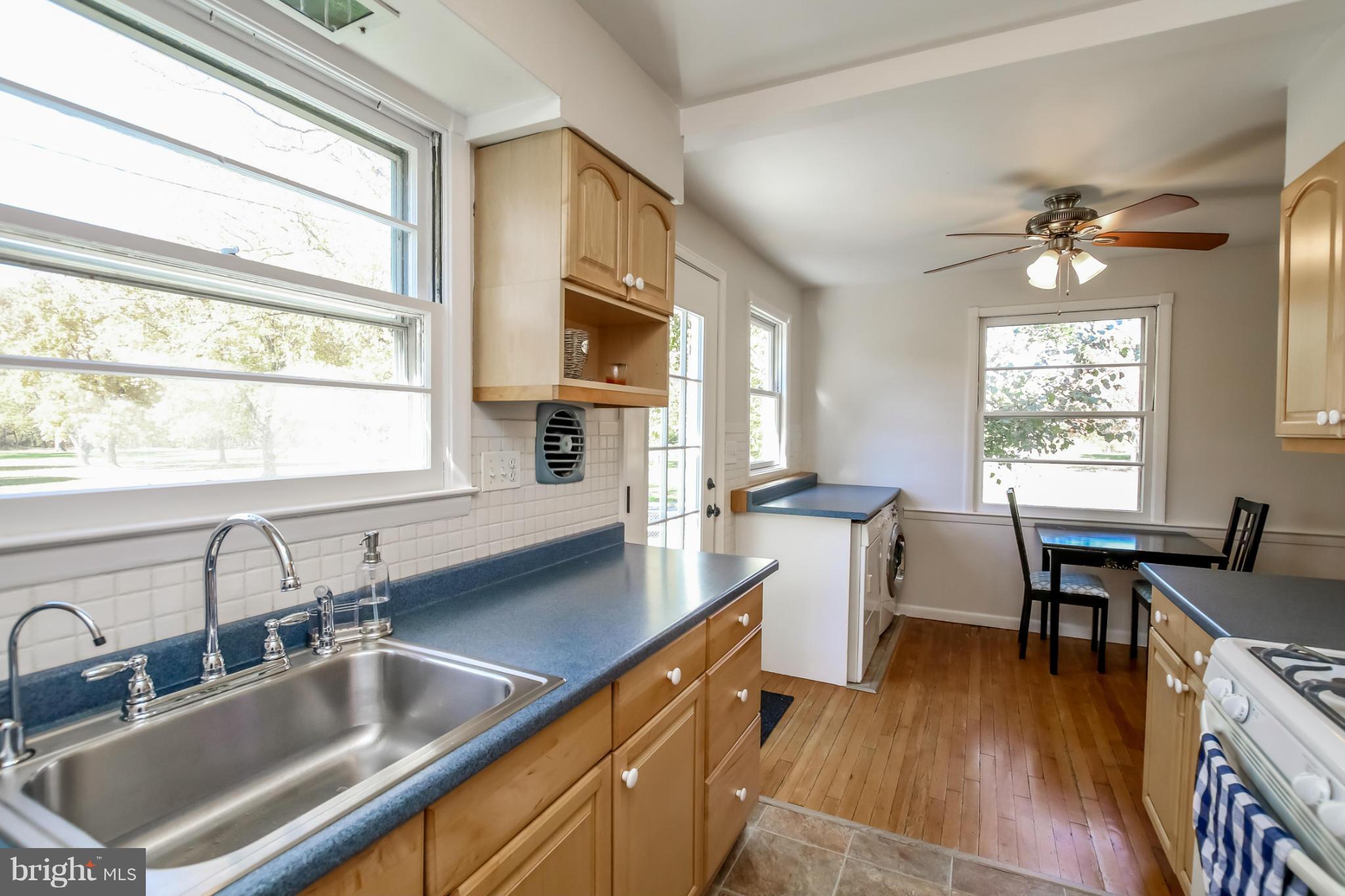 832 Templecliff Road Pikesville, MD 21208 - Photo 12 of 30 a kitchen with a sink a counter space dining table and chairs