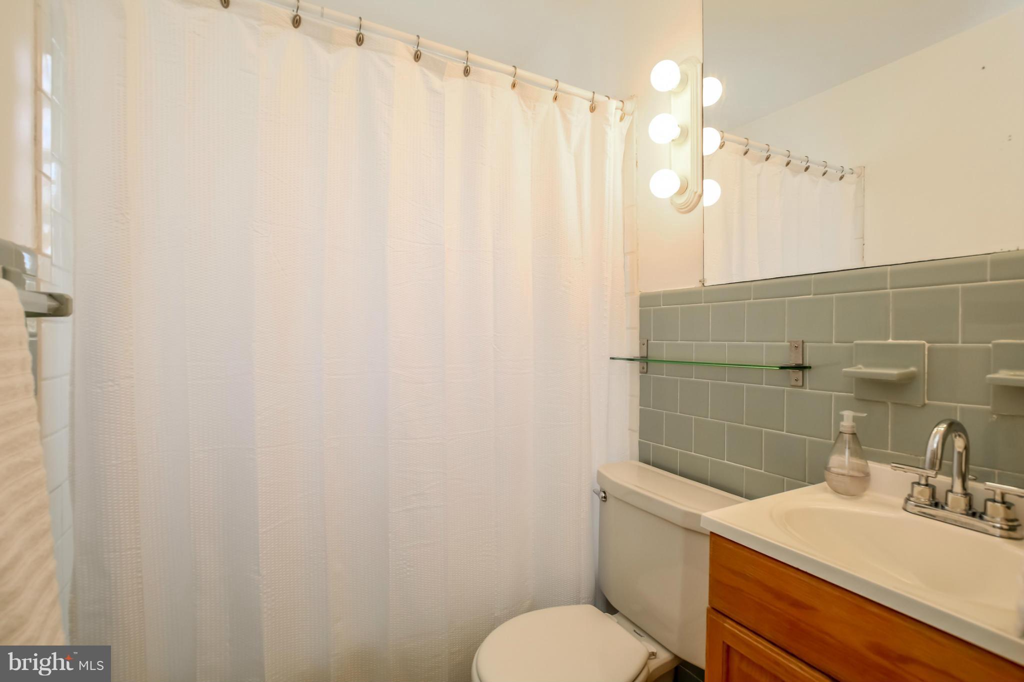 832 Templecliff Road Pikesville, MD 21208 - Photo 16 of 30 a bathroom with a sink a toilet and shower