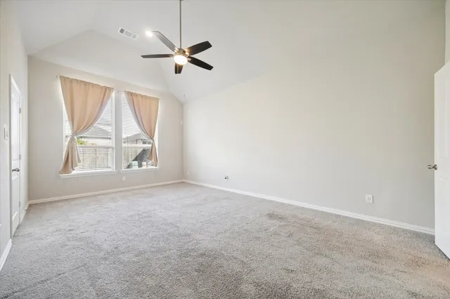 an empty room with windows and fan