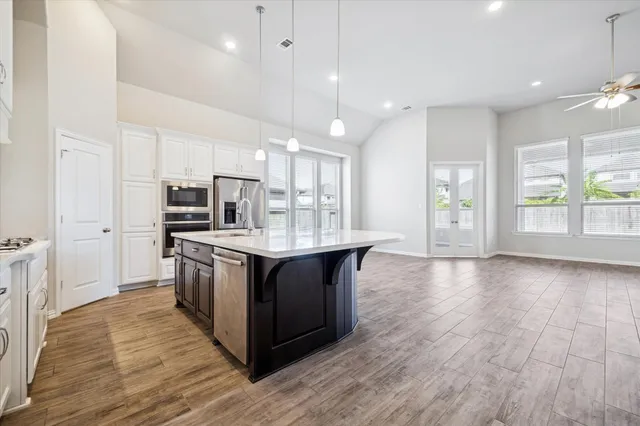 a kitchen with stainless steel appliances granite countertop a wooden cabinets a stove a sink and a refrigerator