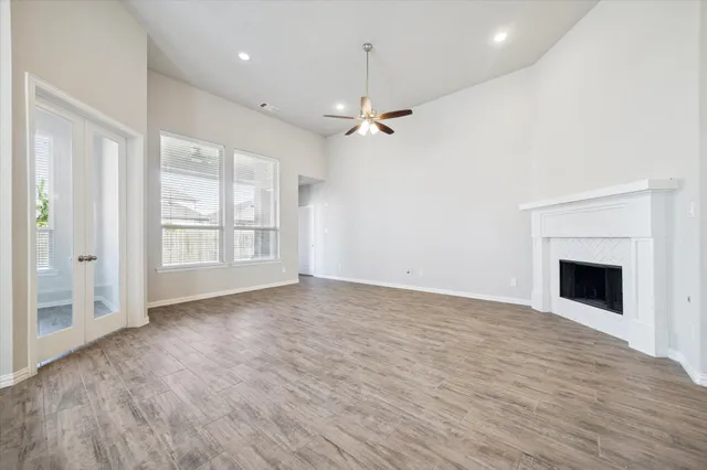 an empty room with windows and fireplace