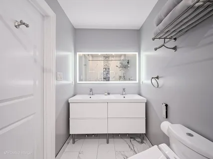 a bathroom with a sink a toilet and mirror