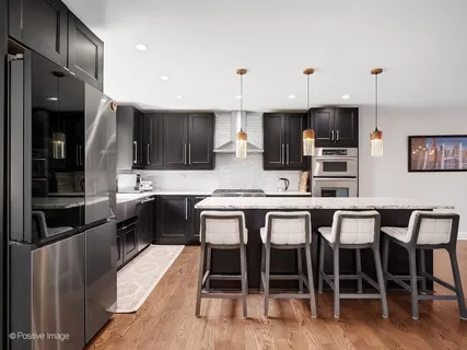 a kitchen with granite countertop a table chairs microwave and cabinets