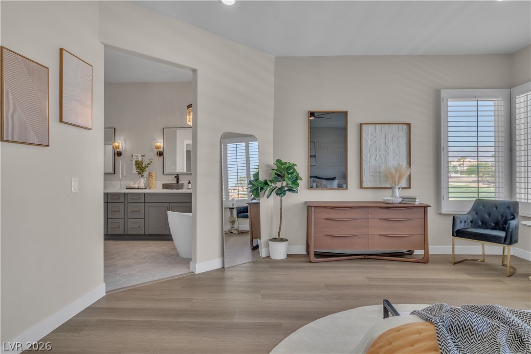8848 Rainbow Ridge Drive Las Vegas, NV 89117 - Photo 27 of 43 Natural light floods this primary bedroom suite, offering scenic views and a seamless transition to a luxurious private bathroom.