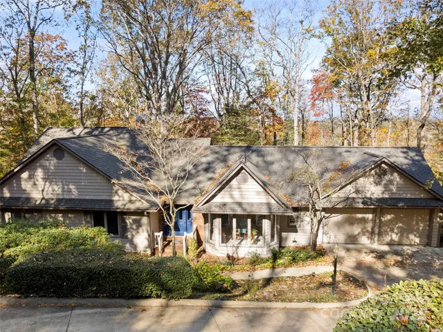 a front view of a house with a yard and potted plants