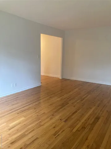 a view of an empty room and wooden floor