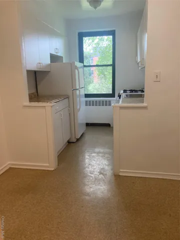 a view of a kitchen with microwave and refrigerator