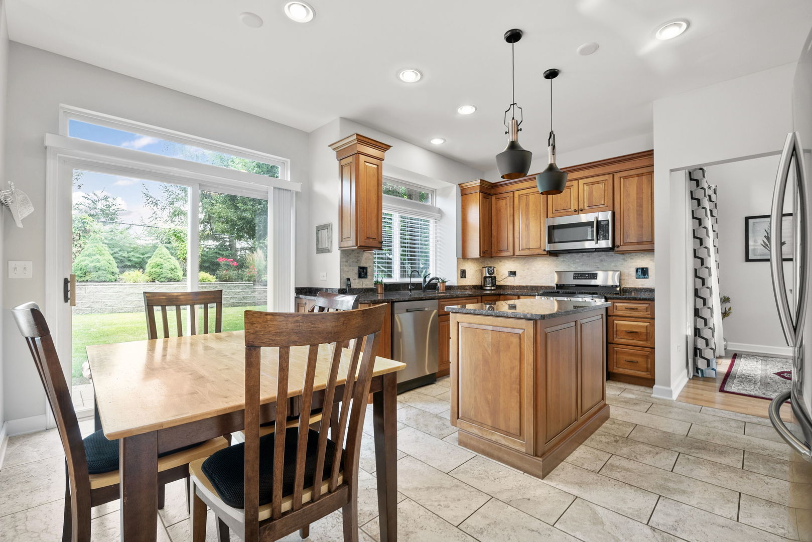 2011 Baldwin Way Bolingbrook, IL 60490 - Photo 8 of 21 a kitchen with stainless steel appliances granite countertop a stove a refrigerator a kitchen island a table and chairs