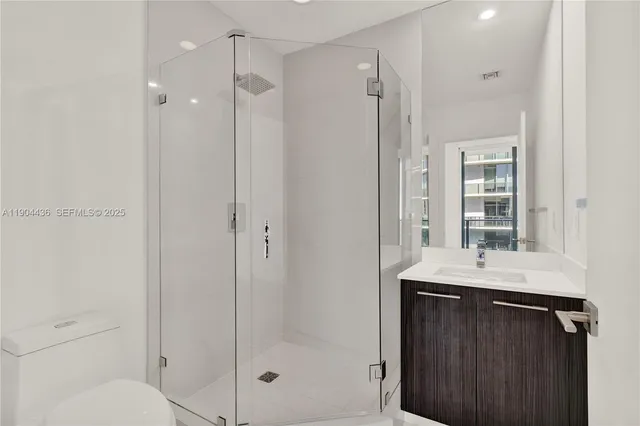 a bathroom with a shower sink vanity and mirror