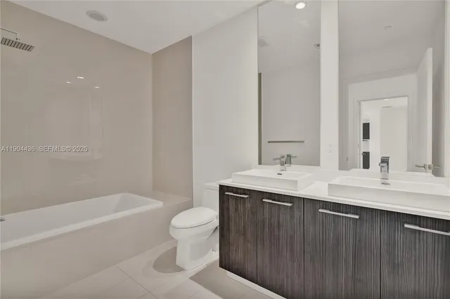 a bathroom with a granite countertop sink a toilet and bathtub