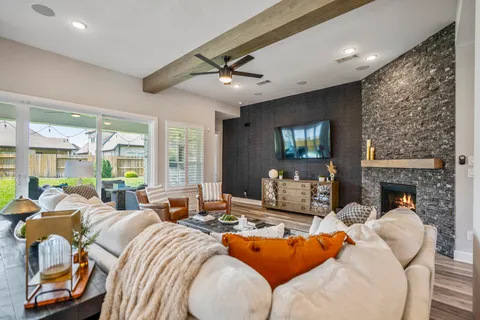 a living room with furniture fireplace and large windows