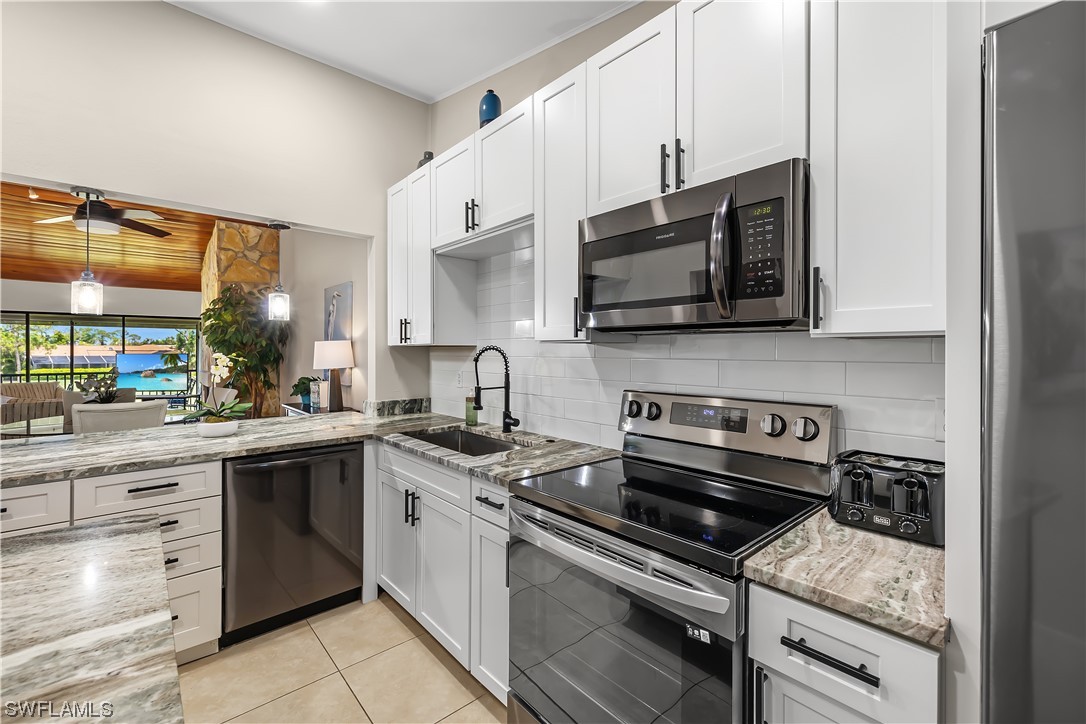 16650 Partridge Place Road, Unit 201 Fort Myers, FL 33908 - Photo 5 of 32 a kitchen with stainless steel appliances granite countertop a stove and a microwave