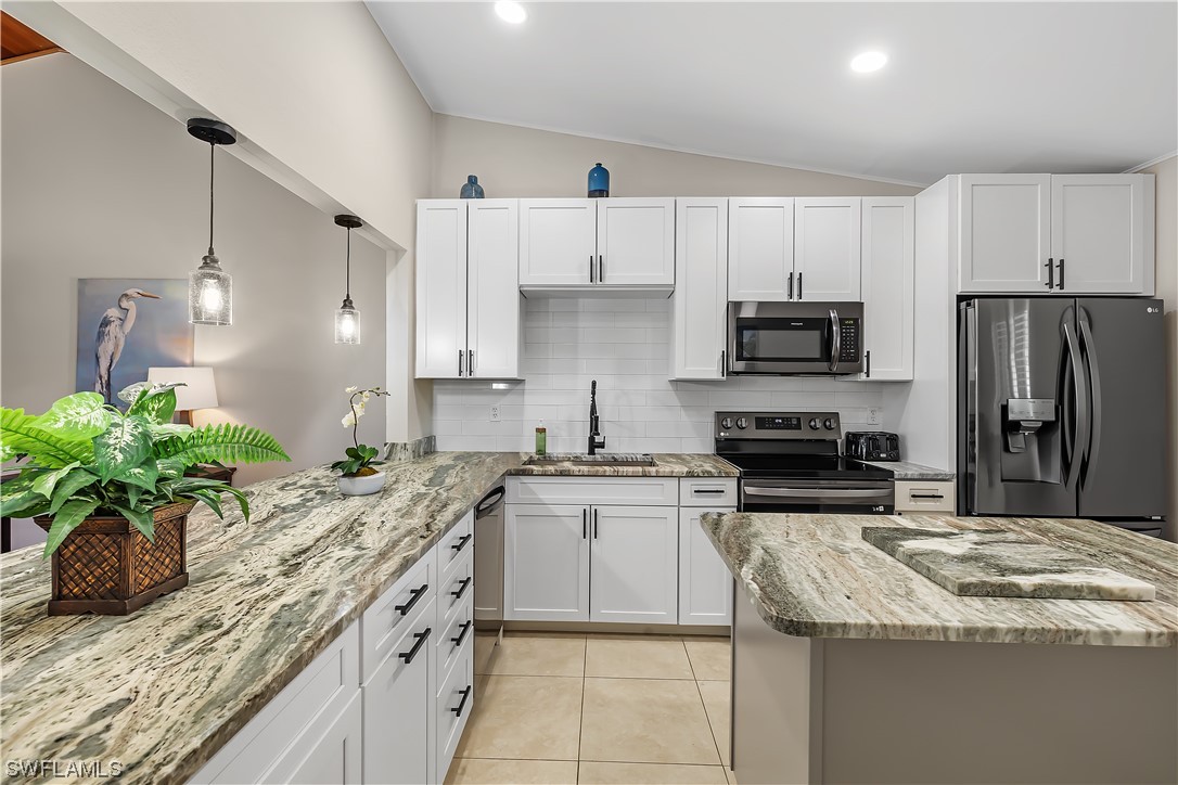 16650 Partridge Place Road, Unit 201 Fort Myers, FL 33908 - Photo 6 of 32 a kitchen with kitchen island granite countertop a sink stainless steel appliances and cabinets