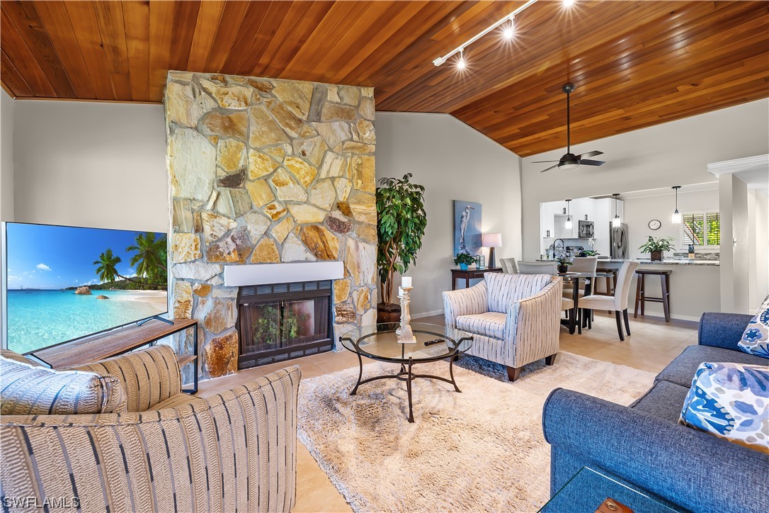 16650 Partridge Place Road, Unit 201 Fort Myers, FL 33908 - Photo 10 of 32 a living room with furniture a fireplace and a flat screen tv