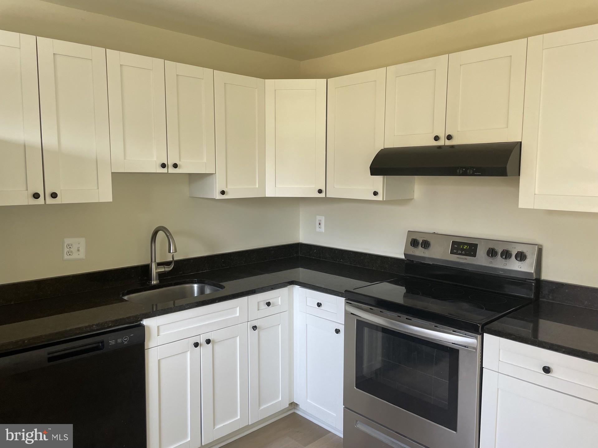 1287 Springtide Place Herndon, VA 20170 - Photo 7 of 23 a kitchen with granite countertop white cabinets and black appliances