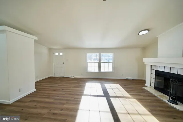 an empty room with windows and fireplace