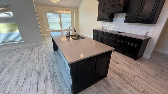 a kitchen with wooden floors a sink and a stove