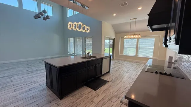 a large kitchen with kitchen island a sink dishwasher stove and wooden floor