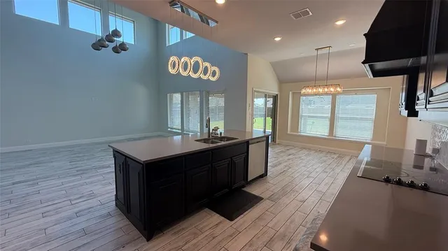 a large kitchen with stainless steel appliances granite countertop a sink a stove and a wooden floors