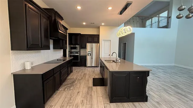 a kitchen with stainless steel appliances a sink stove and refrigerator