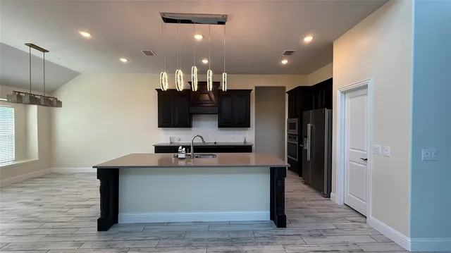 a large kitchen with a large counter top appliances and cabinets