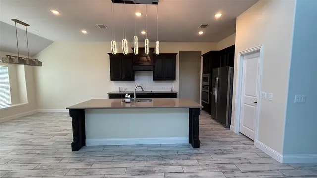 a view of kitchen with sink microwave and refrigerator