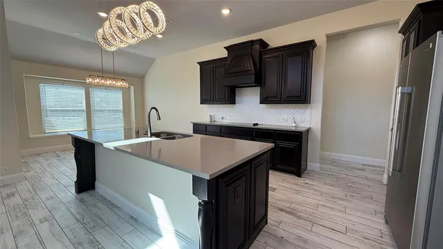a kitchen with a wooden floor and a refrigerator