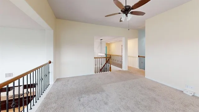 a view of a hallway with a chandelier fan and windows