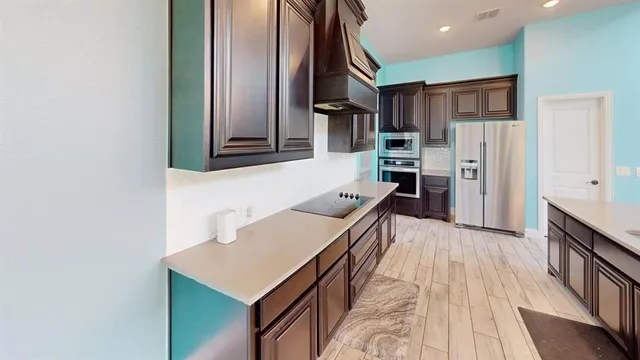 a kitchen with stainless steel appliances kitchen island granite countertop a refrigerator and a stove top oven