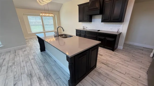 a kitchen with a sink and wooden floor