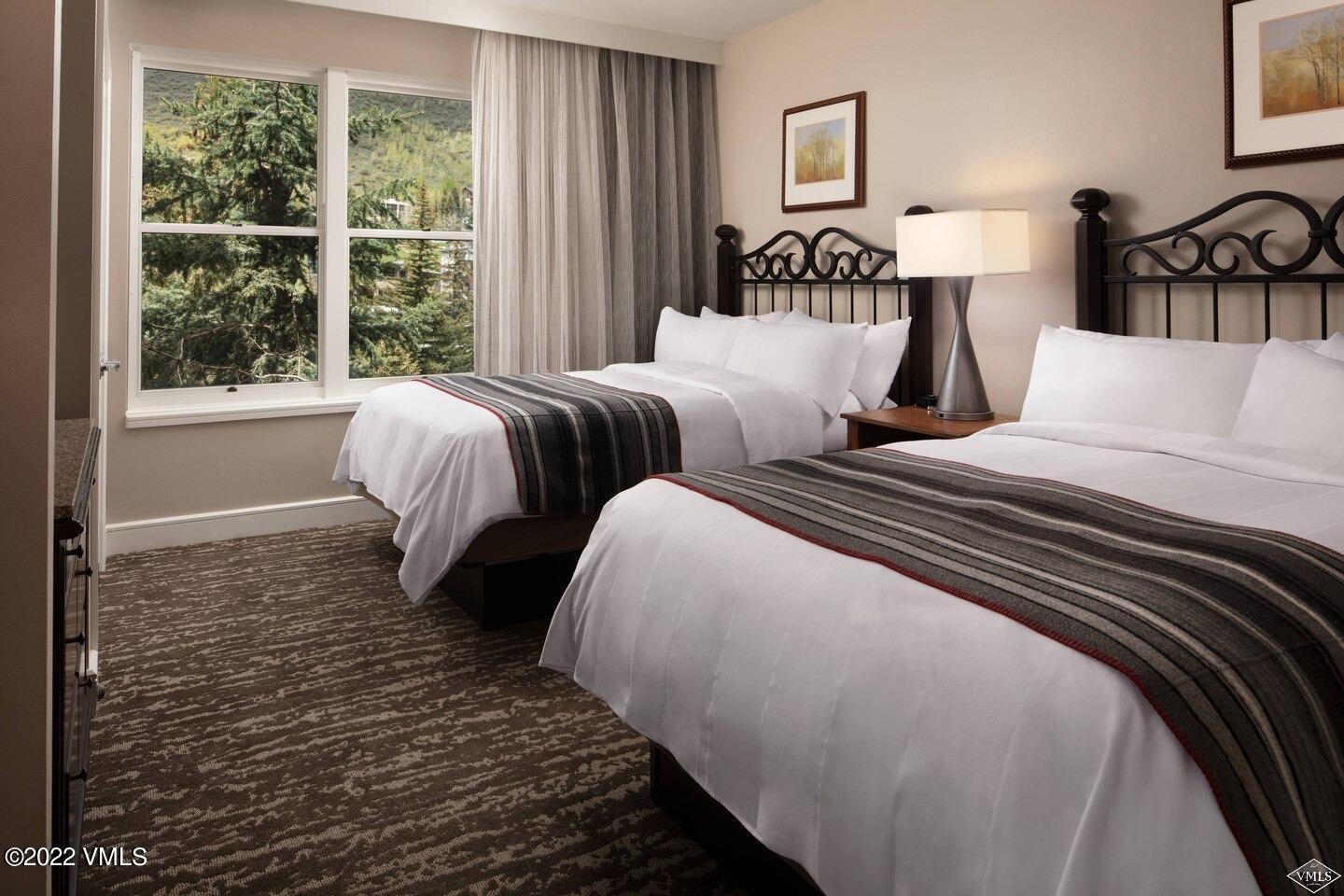 2284 South Frontage Road West Vail, CO 81657 - Photo 3 of 8 a bedroom with two beds and a large window