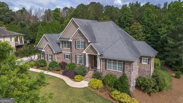 a aerial view of a house with yard and trees in the background