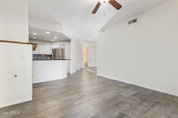 an empty room with wooden floor and windows