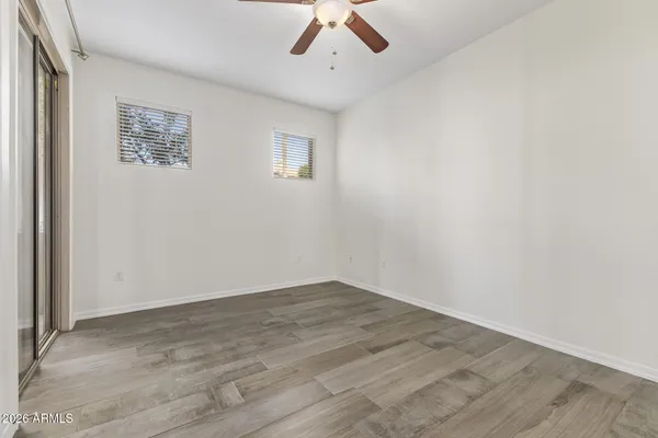 an empty room with wooden floor and windows