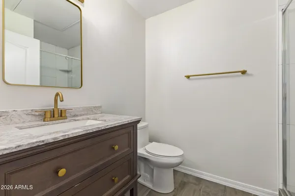 a bathroom with a granite countertop toilet and a sink