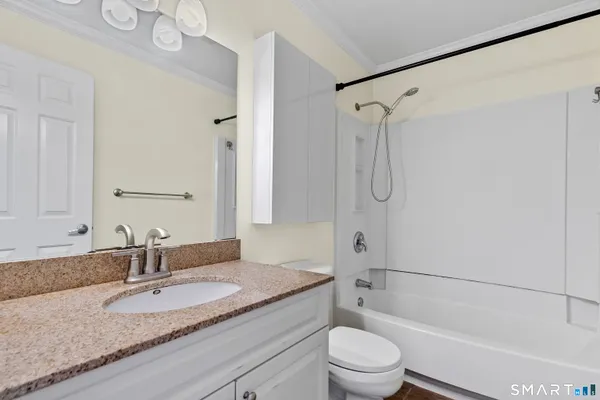 a bathroom with a granite countertop sink toilet and shower