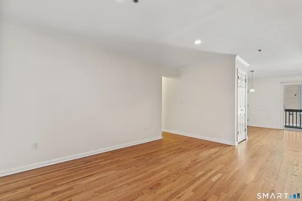 a view of an empty room with wooden floor