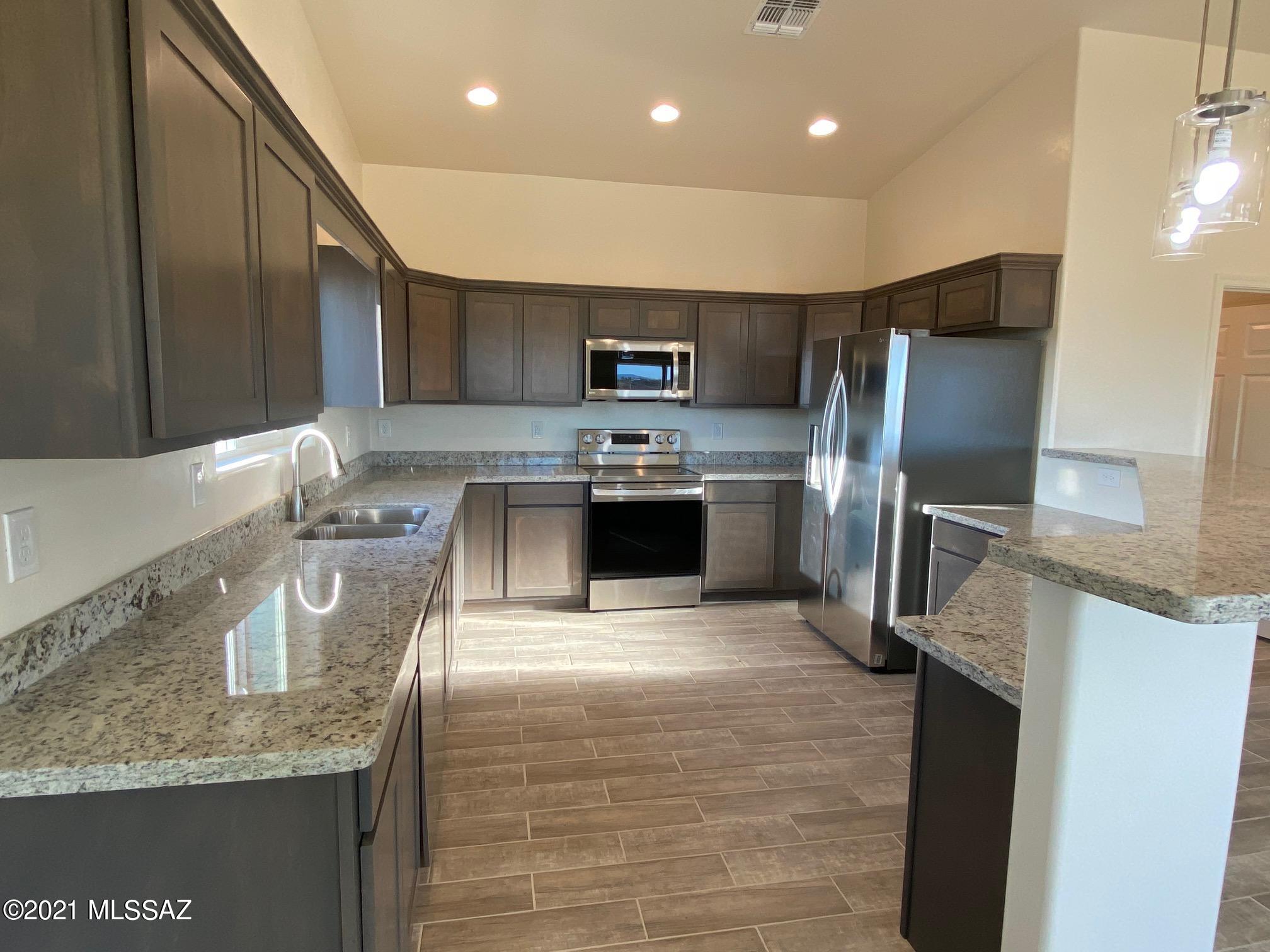 77 Ver Patria Rio Rico, AZ 85648 - Photo 9 of 50 a kitchen with stainless steel appliances granite countertop a sink stove and refrigerator