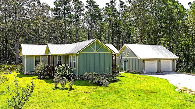 a view of a house with big yard and potted plants