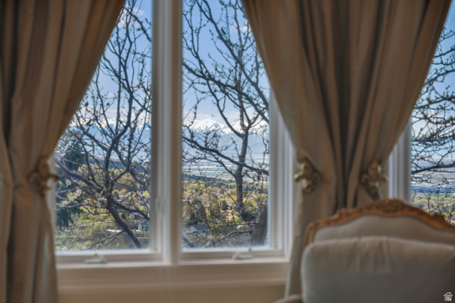 1714 Ridge Point Drive Bountiful, UT 84010 - Photo 63 of 132 White-framed windows with decorative drapery overlooking a snow-capped mountain range and distant landscape